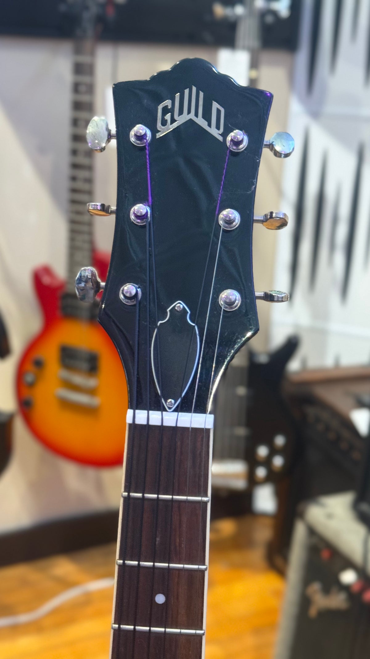 Guild headstock front showing logo and visible edge wear