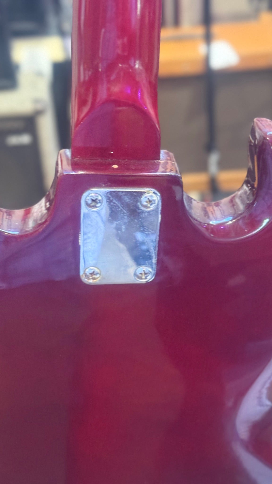 Unbranded SG-style guitar — rear neck joint, four-bolt plate and upper body detail
